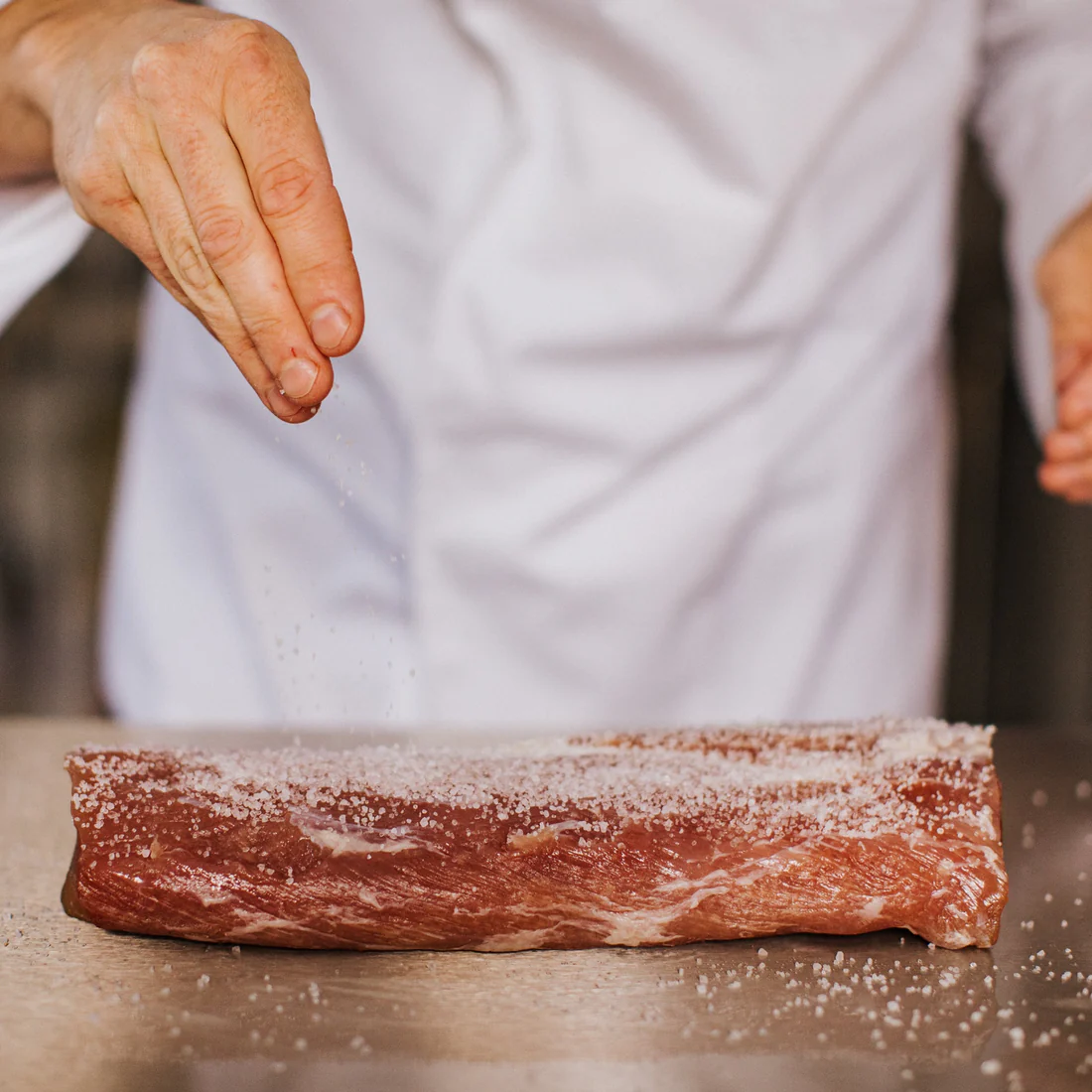 The Greek Farmer cured meat being prepared by hand